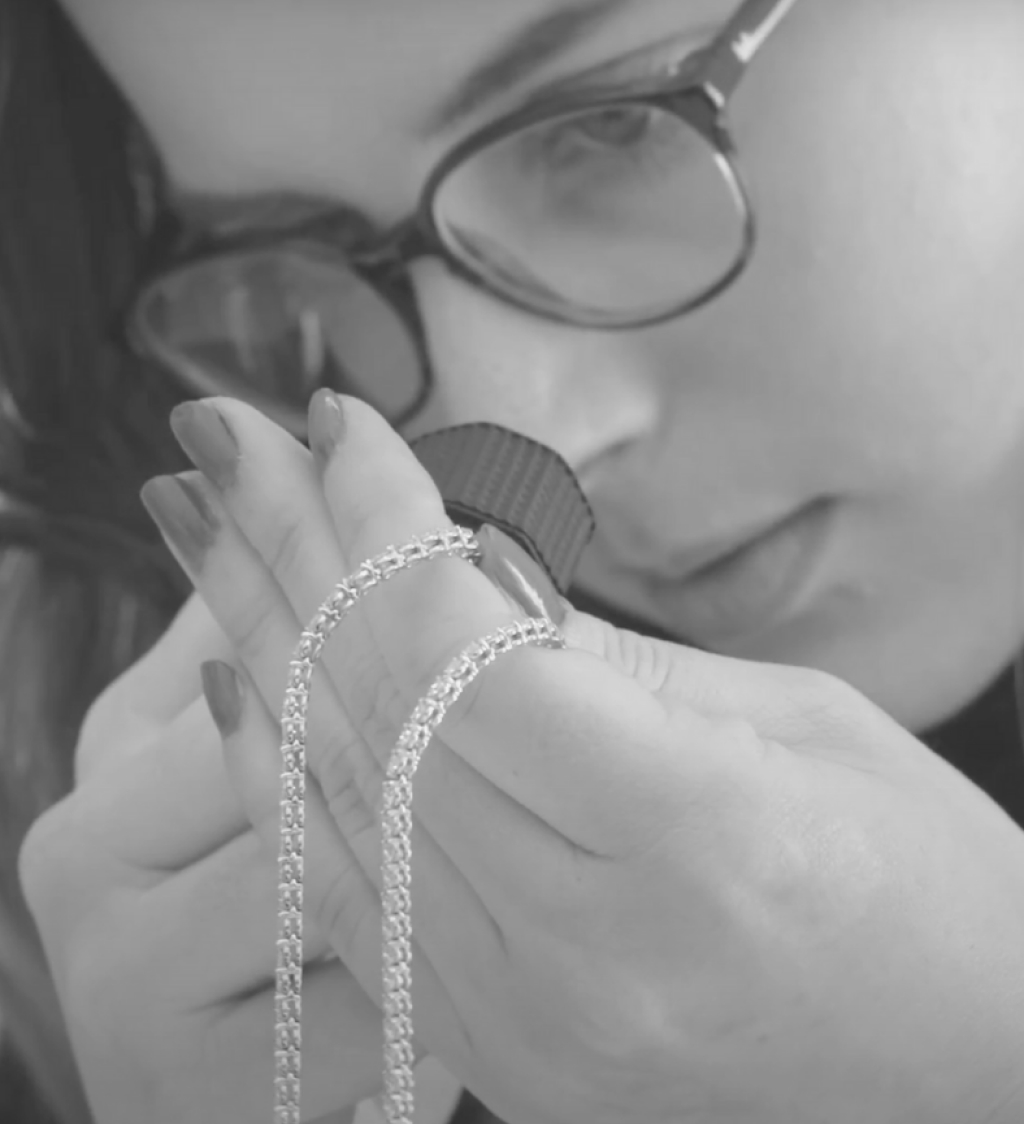 Jeweler with loupe inspecting a diamond necklace